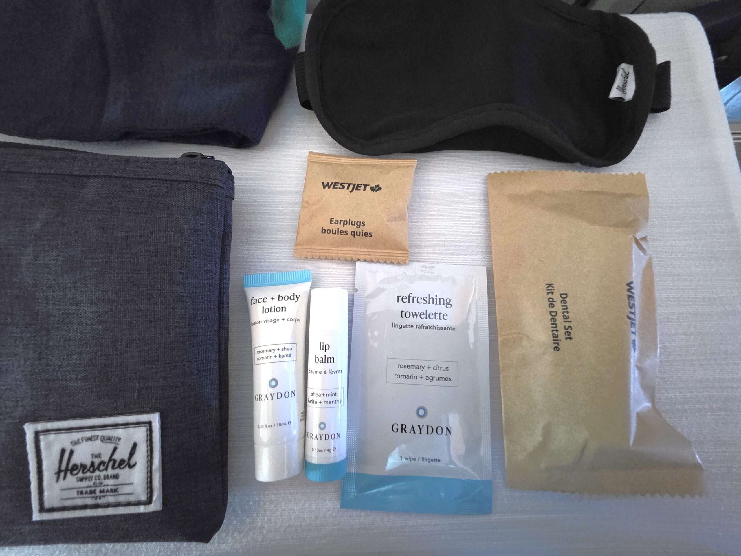 WestJet Premium Economy Herschel amenity kit skincare lotion lip balm face cream