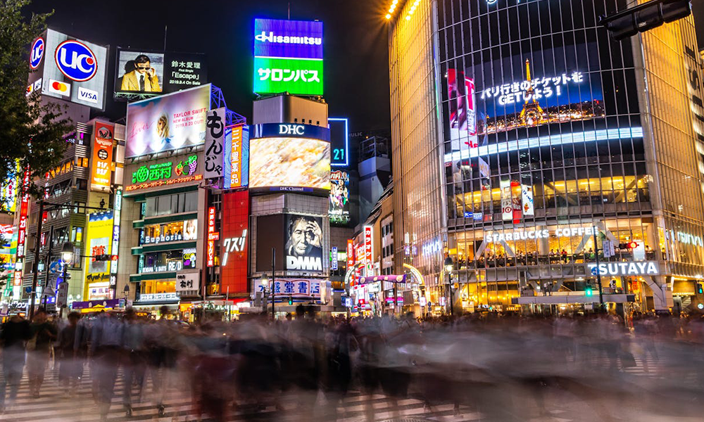 Tokyo Japan Shibuya crossing neon signs night digital nomad winter travel