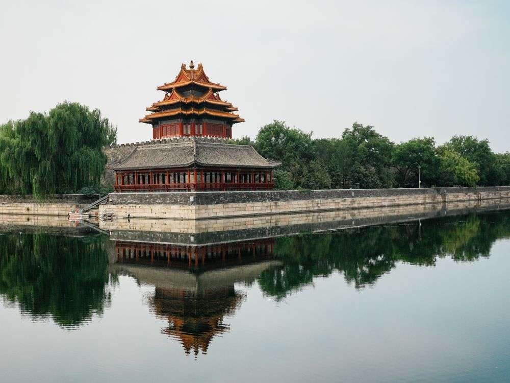 The iconic corner tower of the Forbidden City reflected in the surrounding moat